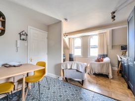A living room with dining table and yellow chairs at Lil Nauti in Fowey