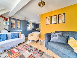 A living room with sofas and a rug at Lil Nauti in Fowey