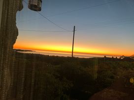 A sunset view overlooking water and landscape at Bwthyn Nain 