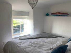 A bedroom with a bed and window at Bwthyn Nain