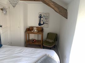 A bedroom with a bed, table, chair, and decor at Bwthyn Nain