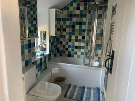 A bathroom with a bathtub and toilet at Bwthyn Nain