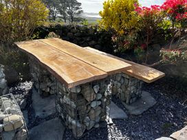 A wooden table supported by stone structures in a garden at Bwthyn Nain 