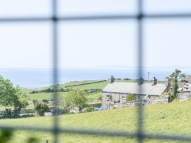 A view of houses and sea from the window at Bwthyn Nain in Harlech