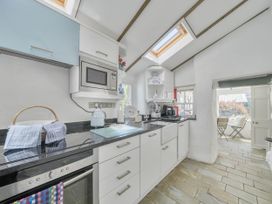 A kitchen with cabinets and appliances at Bwthyn Nain in Harlech