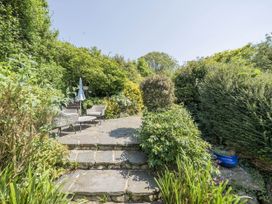 A garden with stone steps leading to seating area at Bwthyn Nain in Harlech