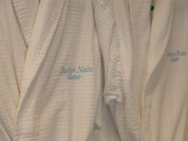 Bathrobes hanging with Bwthyn Nain embroidery in a bathroom