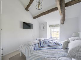 A bedroom with a bed and television at Bwthyn Nain in Harlech