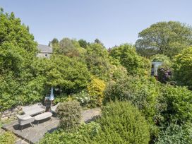 A garden with a sofa, table, and plants at Bwthyn Nain in Harlech
