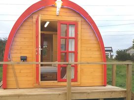 A wooden glamping pod with a deck at St Austell Glamping