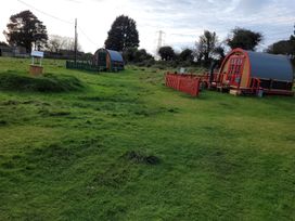 An outdoor area with unique shelters and furniture at St Austell Glamping