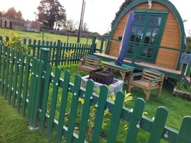 A garden with outdoor furniture and a glamping pod at St Austell Glamping