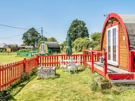 A garden with glamping pods and outdoor seating at St Austell Glamping St Austell