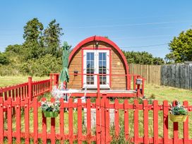 A cabin with a red fence and patio at St Austell Glamping in St Austell
