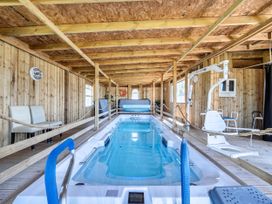 An indoor pool area with a swimming pool and pool lift at St Austell Glamping in St Austell