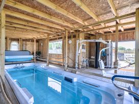 An indoor pool with exercise equipment at St Austell Glamping in St Austell