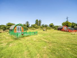 An outdoor area with green and red cabins at St Austell Glamping in St Austell