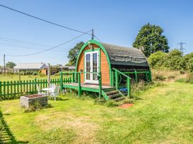 A wooden cabin with steps and a green fence at St Austell Glamping in St Austell
