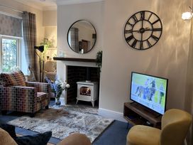 A living room with a television and a fireplace at The Old Barn in Manchester