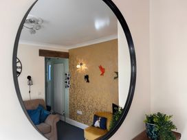 A living room with a mirror reflecting decor and furniture at The Old Barn in Manchester
