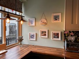 A kitchen with framed pictures on the wall and a window at 