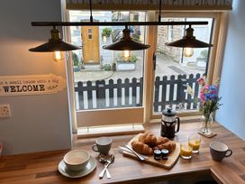 A kitchen table with breakfast items and a window at a small house