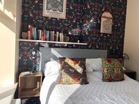 A bed with pillows and a bookshelf in a bedroom at The Old Barn in Manchester