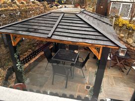 An outdoor seating area with a gazebo and furniture at the property