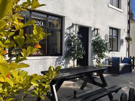 An outdoor seating area with a table and chairs at a property with number 20