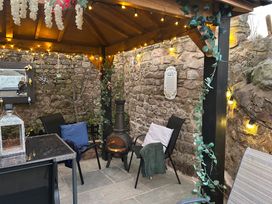 A garden gazebo with seating and a fireplace at The Old Barn in Manchester