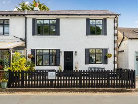 A house with a fence and plants at 20 Main Street in Heysham