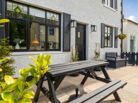 An outdoor seating area with a table and benches at 20 Main Street in Heysham