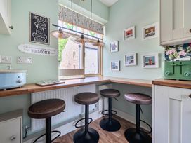 A kitchen with bar stools and a table at 20 Main Street in Heysham