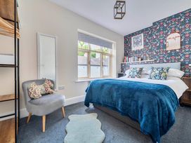 A bedroom with a bed, chair, and window at 20 Main Street in Heysham