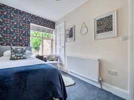 A bedroom with a bed and decorative wallpaper at 20 Main Street in Heysham
