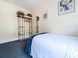 A bedroom with a bed and storage shelf at 20 Main Street in Heysham
