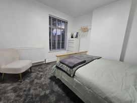 A bedroom with a bed and a chair at 140 Finchley Road