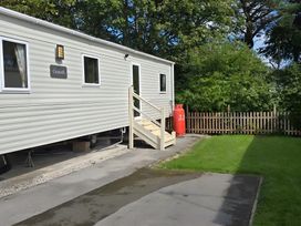 An outdoor area with a caravan and a lawn at Caravan
