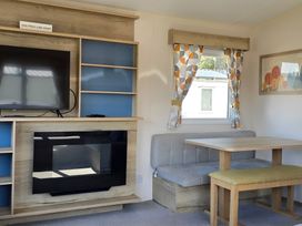 A living room with a television and a table at Caravan