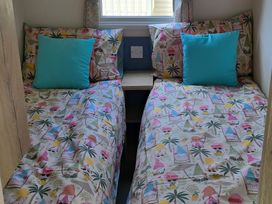 A bedroom with two single beds and a nightstand at Caravan 