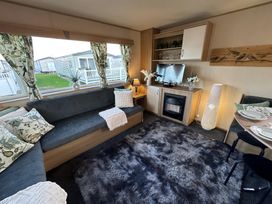 A living room with a sofa and television at the holiday home in unspecified location
