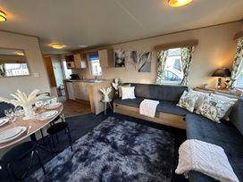 A living room with a sofa and dining area at The Old Barn in Manchester