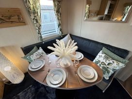 A dining area with a round table and plates at The Old Barn in Manchester
