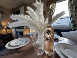 A dining table set with plates and wine bottle at a dining area in a property