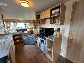 A kitchen with stove, sink, refrigerator and countertop in a modern setting