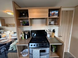 A kitchen with stove and appliances at The Old Barn in Manchester