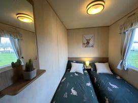 A bedroom with two beds and a mirror at a property in an outdoor setting