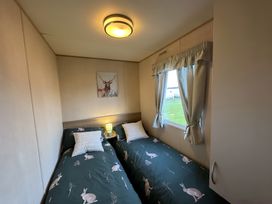 A bedroom with two beds and a window situated at The Cottage in an unspecified location