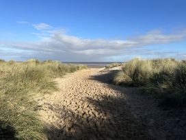 A path through grass leading to the sea at a beach