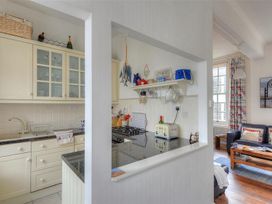 A kitchen with appliances and a view of the living area at 1 The Old Posthouse Lyme Regis